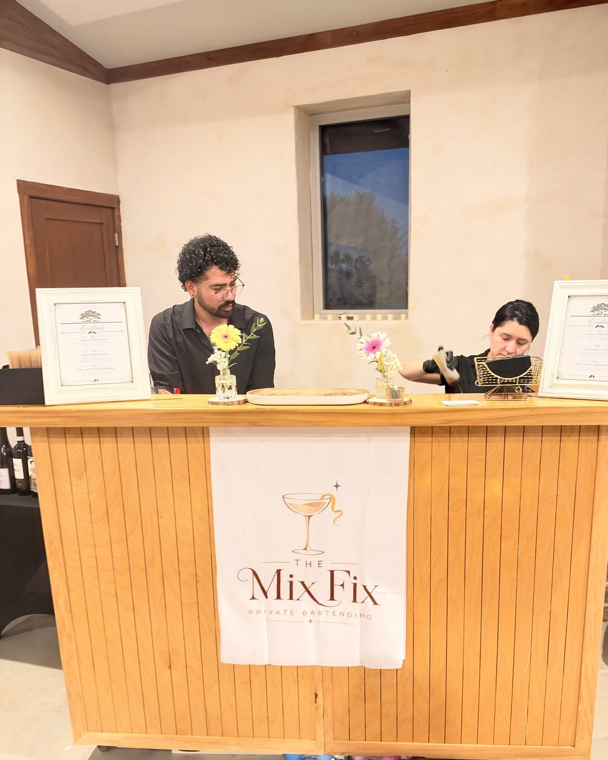 Two Mix Fix bartenders working behind the handcrafted wooden bar